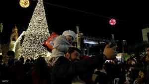 Palestinian Christians take pictures of a Christmas tree at the Manger Square near the Church of the Nativity, revered as the site of Jesus Christ's birth, on December 3, 2016 in the biblical West Bank town of Bethlehem / AFP / MUSA AL SHAER        (Photo credit should read MUSA AL SHAER/AFP/Getty Images)